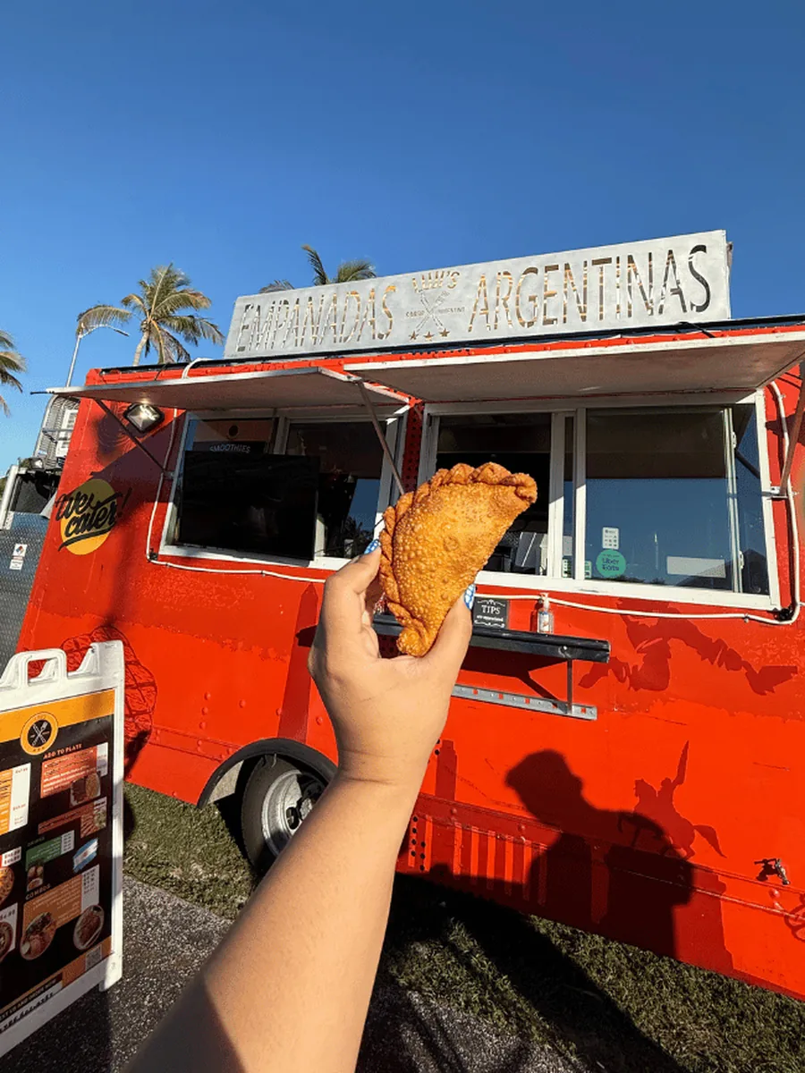 Fresh empanada held up in front of Luji's truck